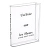 Clear acrylic book vase with flower holder displaying the title Un livre sur les Fleurs