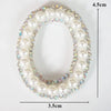 A pearl and rhinestone letter patch for clothing, oval shaped with a 4.5cm height and 3.5cm width.