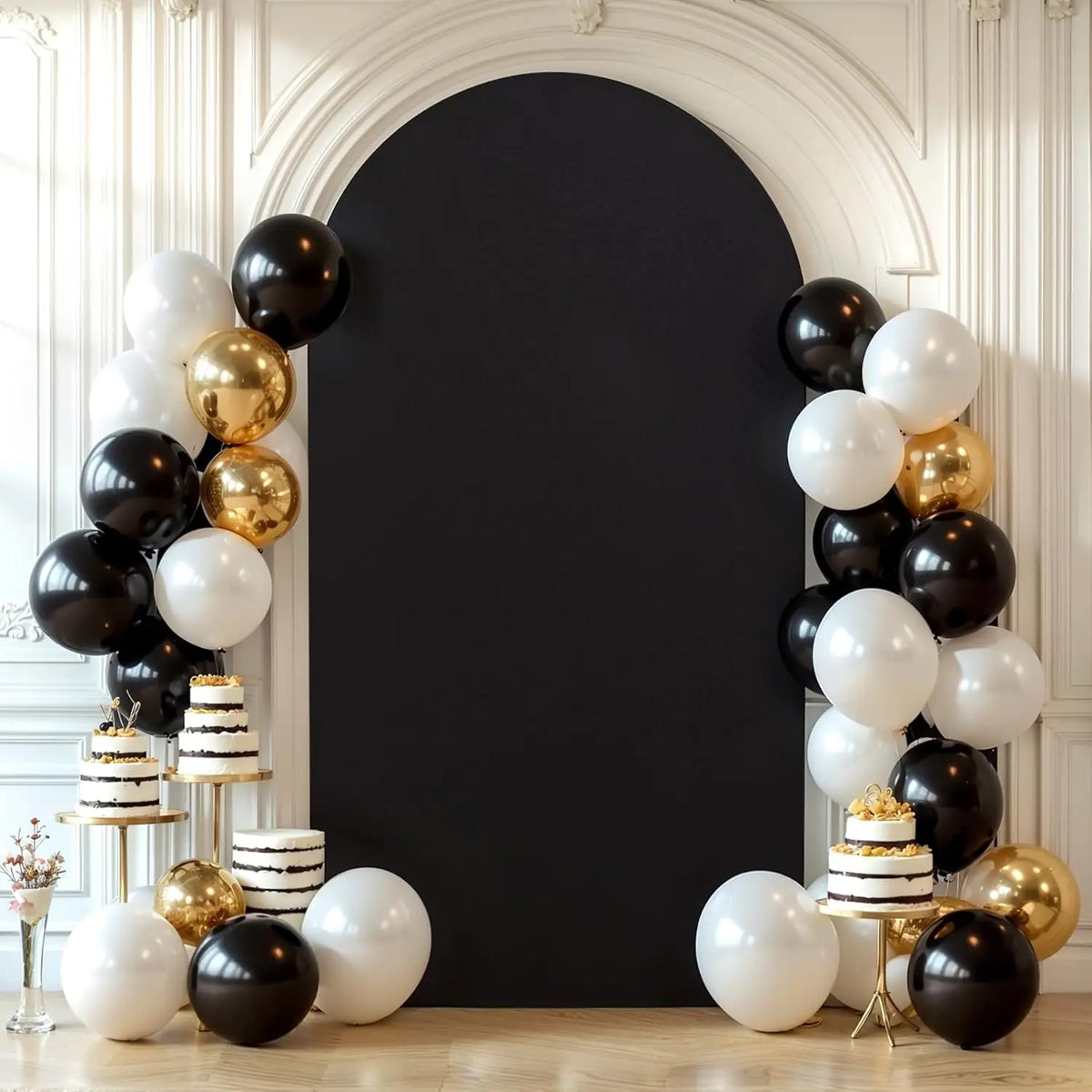A dark gray arch backdrop decorated with white and gold balloons for a wedding or party event.
