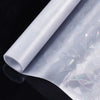 Roll of rainbow holographic privacy window film with static cling displayed on a dark surface.