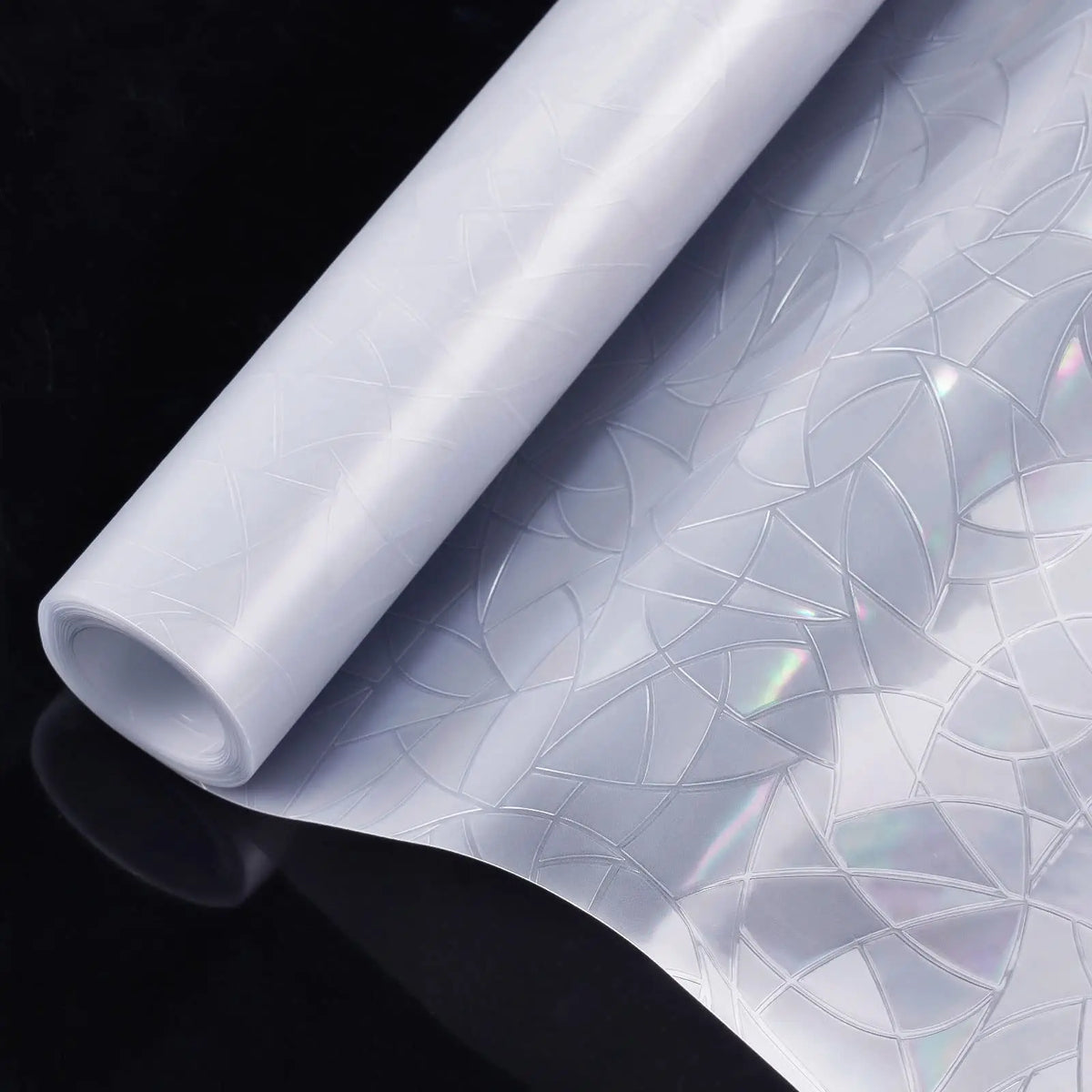 Roll of rainbow holographic privacy window film with static cling displayed on a dark surface.