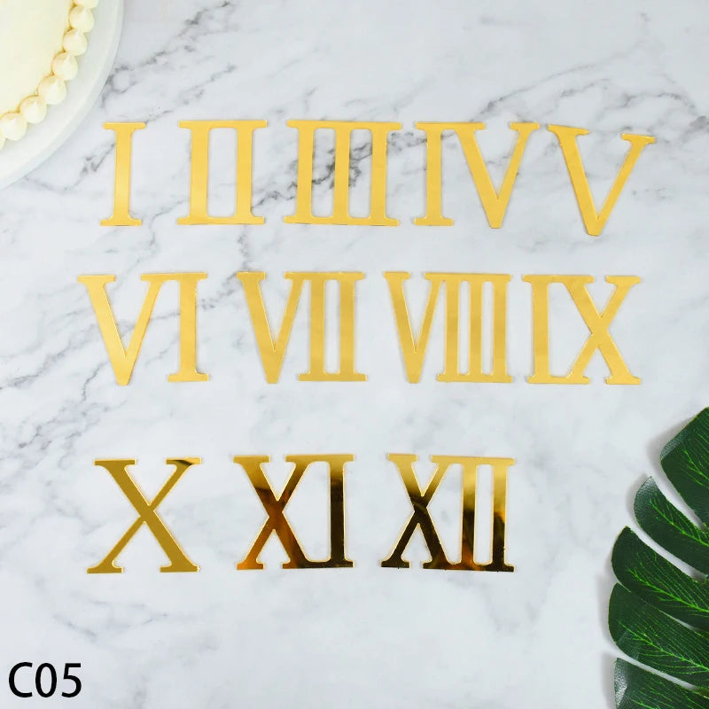 Gold acrylic alphabet Roman numeral cake topper set showing Roman numerals I through XII on a white marble surface