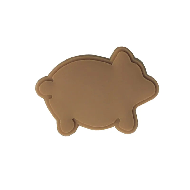 A brown, oval-shaped PVC shoe charm designed in a Mexican style.
