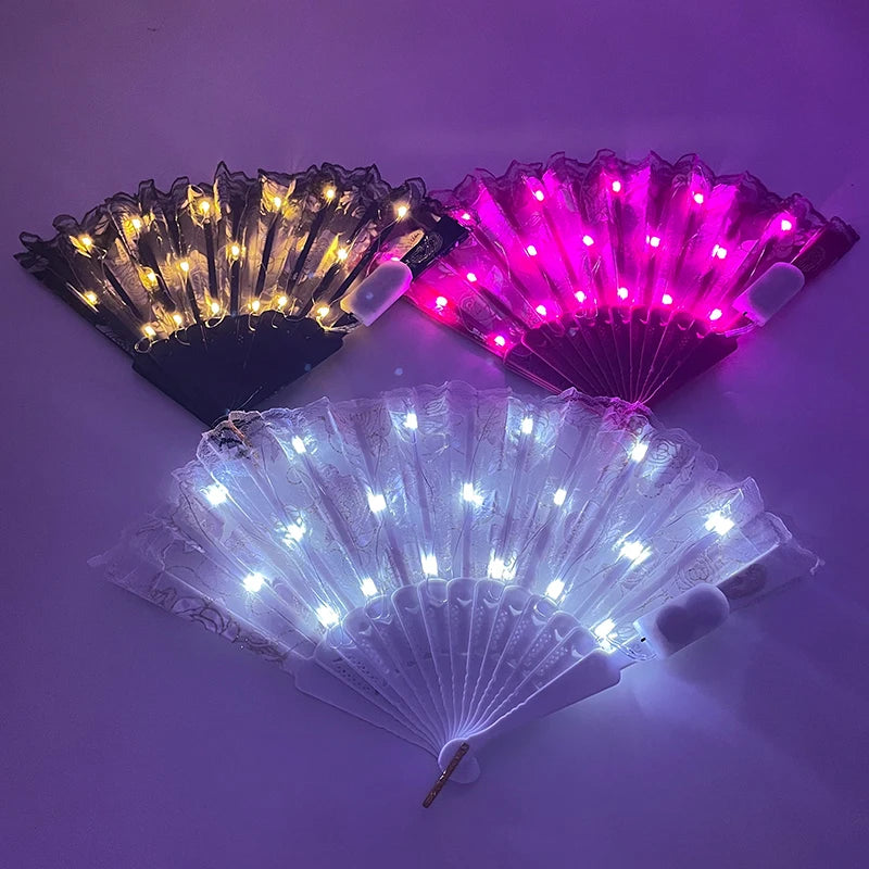 Three LED dancing hand fans glowing in gold, pink, and blue light against a purple background.
