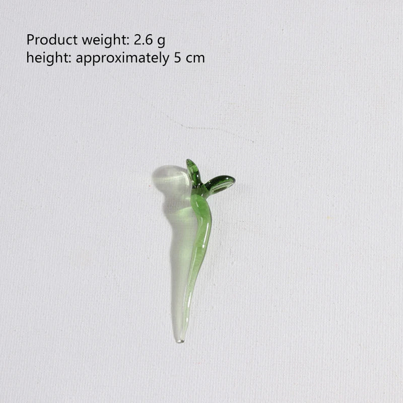 A small, translucent green glass flower with a stem, used for home decor.