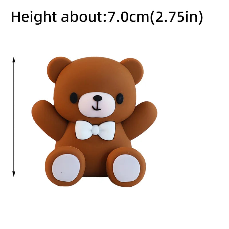 A brown teddy bear cake topper with a white bow and white paws.