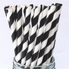 A bundle of black and white striped paper drinking straws in a glass container.