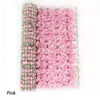 A vertical roll of pink artificial cherry blossom privacy fence screen.