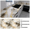 A kitchen countertop featuring a marble pattern with gold veining, installed with an adhesive backing.