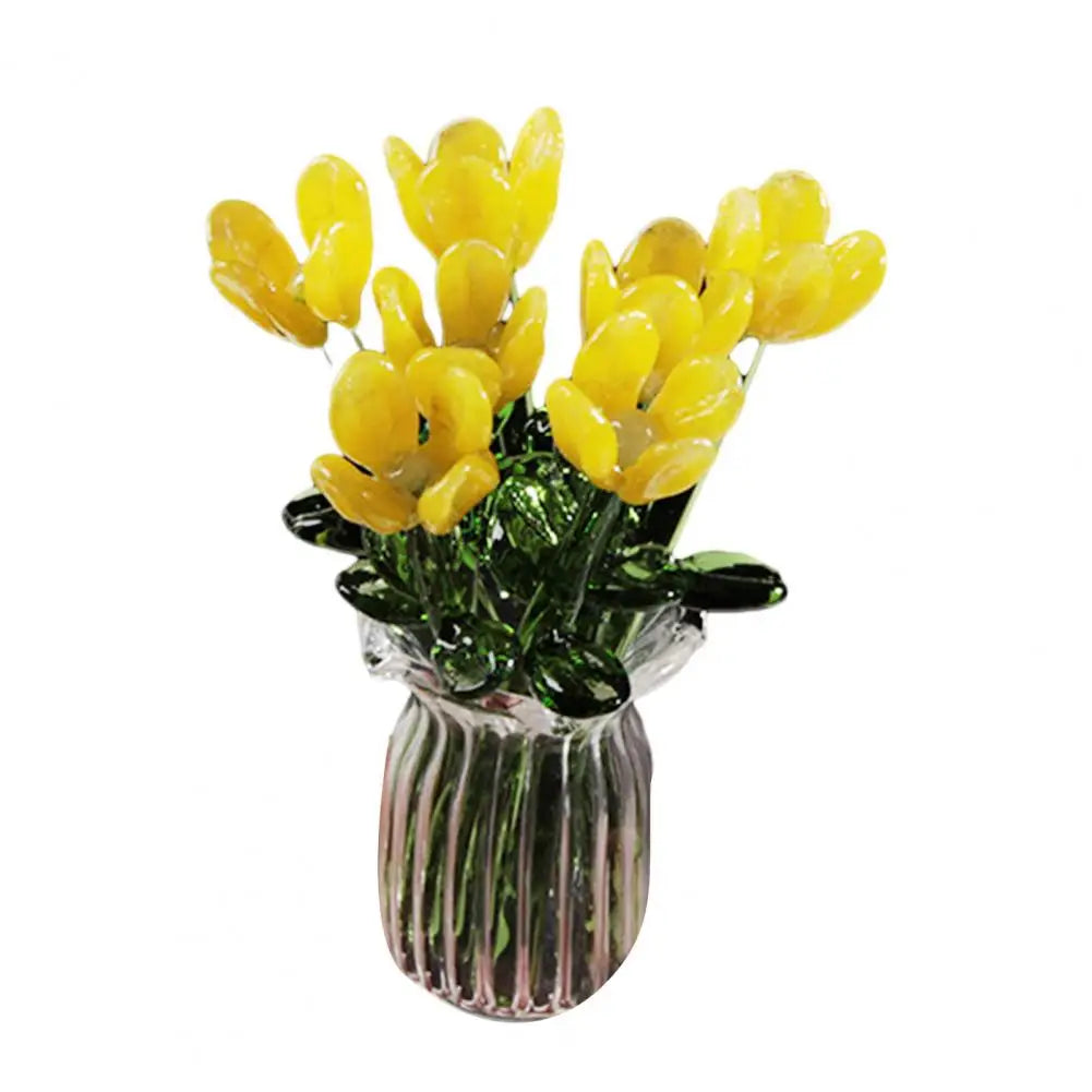 A bouquet of bright yellow hand-blown glass flowers in a clear glass vase.