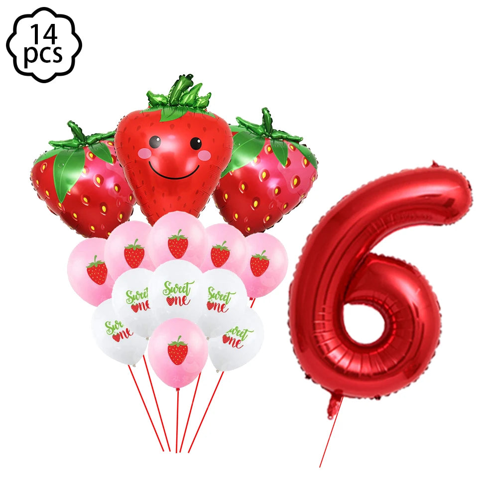 A kit of strawberry-themed party supplies including strawberries, plates, cups, napkins, and a tablecloth.