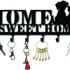 Decorative metal wall-mounted key holder with seven hooks and various keys.