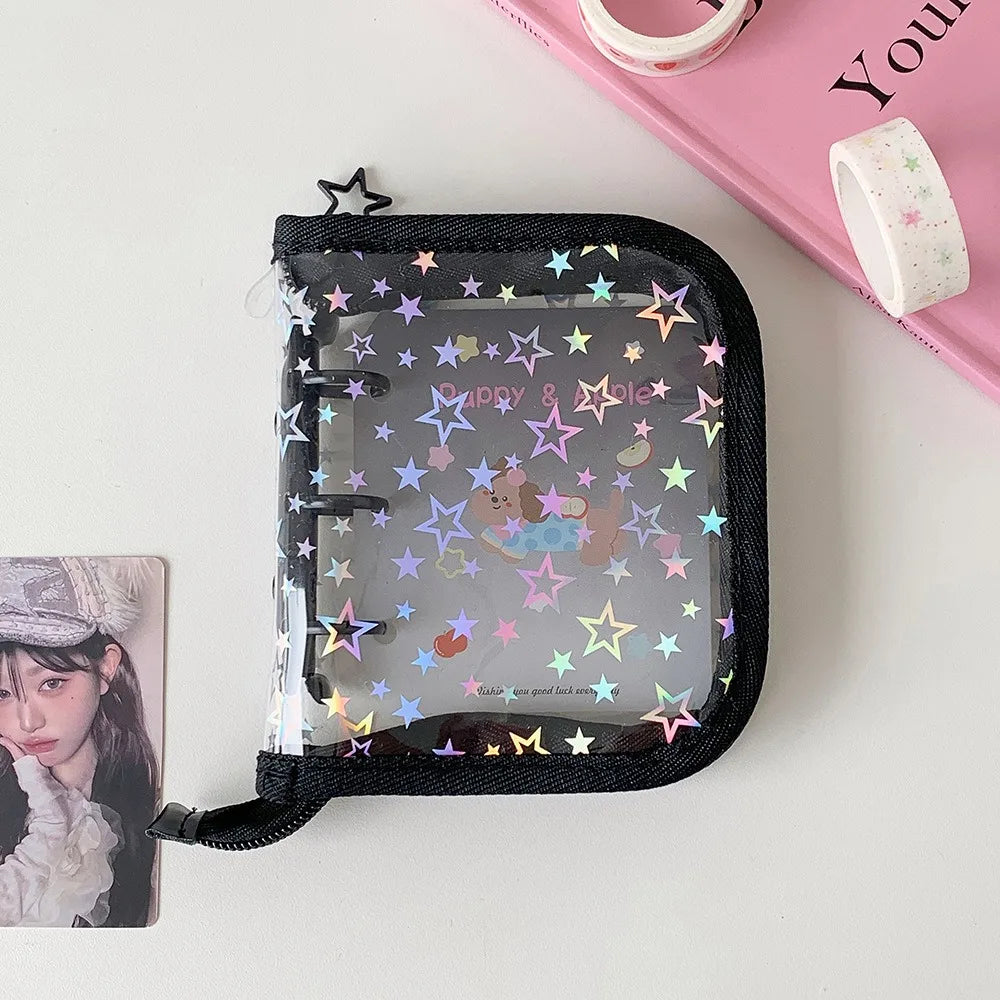 A clear plastic binder with a black elastic closure decorated with colorful glitter stars and a small animal silhouette.