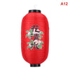 A red Japanese paper hanging lantern with black accents, featuring white and green floral characters.