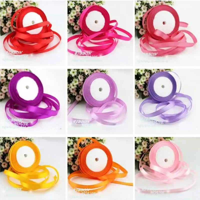 Various rolls of pink silk satin ribbon in different shades and widths displayed on a white background.