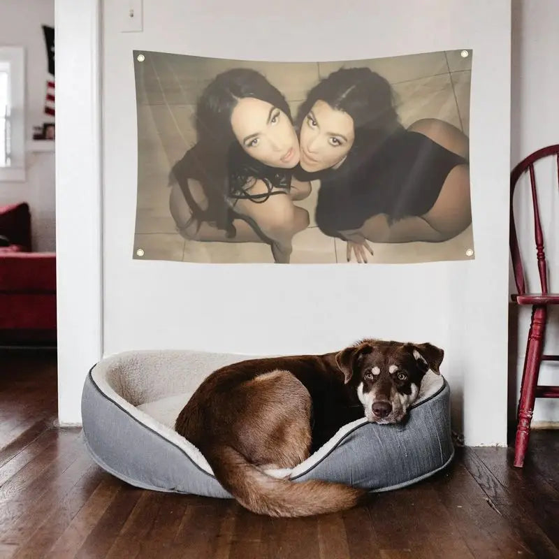 A dark brown dog lies inside a gray fabric bowl on a wooden floor in a bright room.