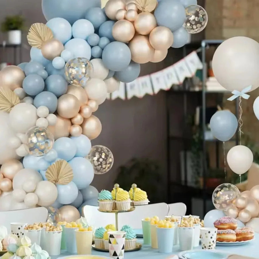 A display of latex balloons in blue, sand, white, and gold arranged in a wreath formation.