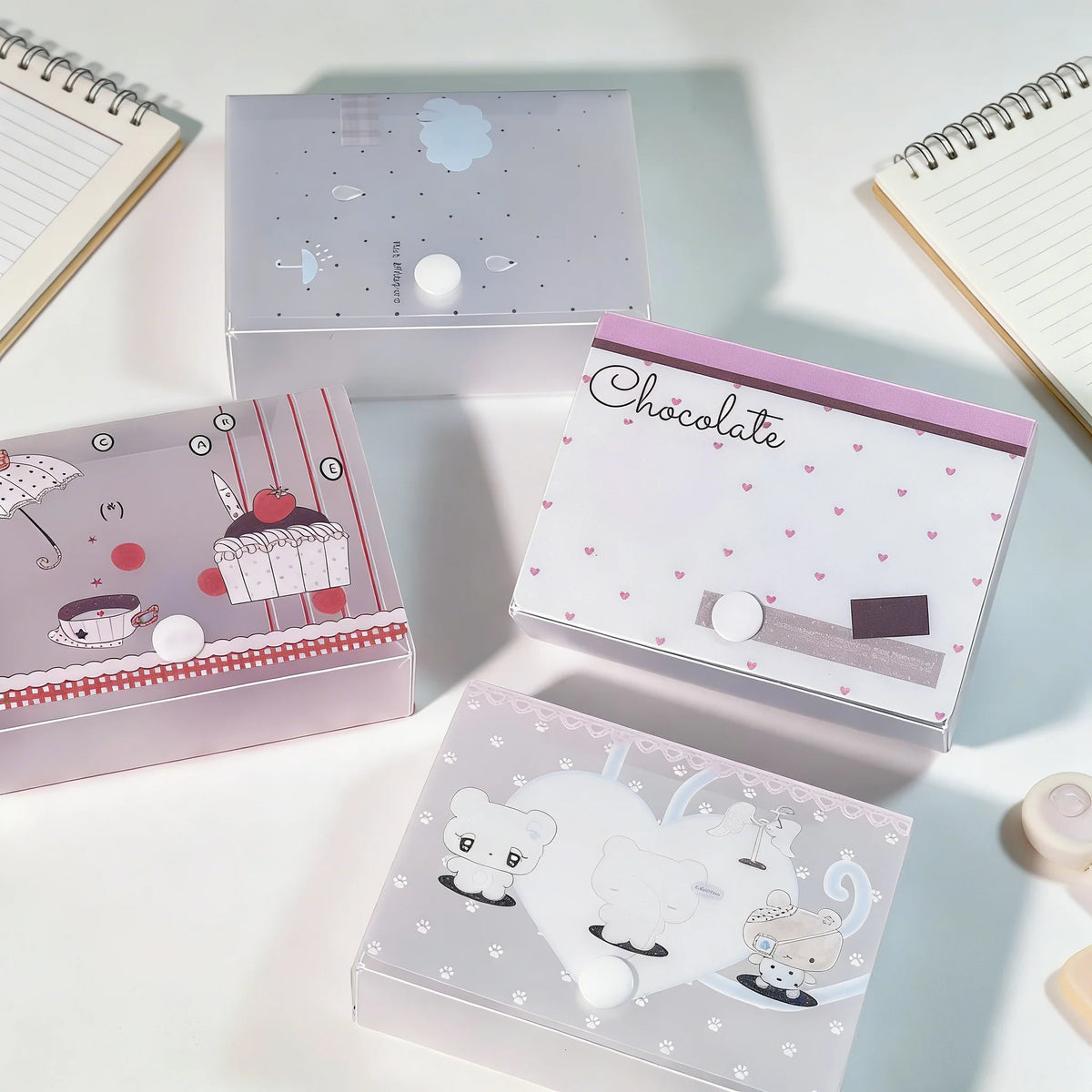 Colección de cajas de almacenamiento minimalistas para pegatinas y tarjetas en varios tonos pastel y diseños.