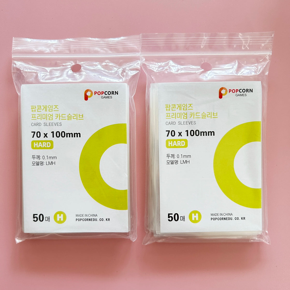 Two sealed packages of POPCORN GAMES premium card sleeves, each containing 50 hard card sleeves.