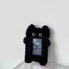 A black plush photocard holder with a zipper closure is displayed against a white background.