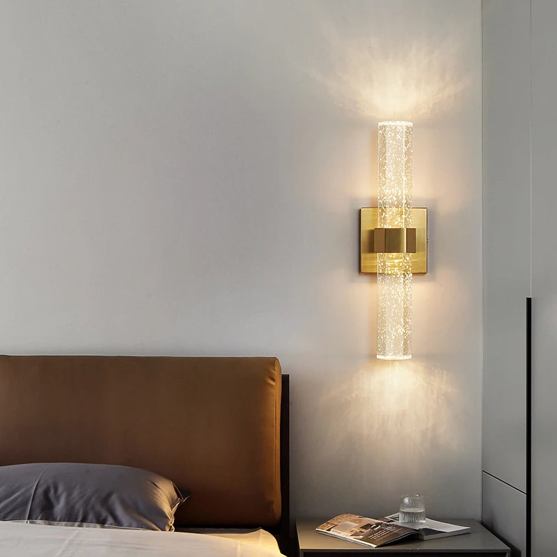 Modern bubble crystal LED wall sconces mounted on a light gray wall above a bed.