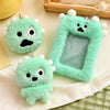 A light green fluffy plush keychain with a clear plastic holder for photos is displayed on a white cloth.