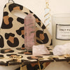 A leopard print wall mounted storage rack displaying amethyst and quartz crystals.