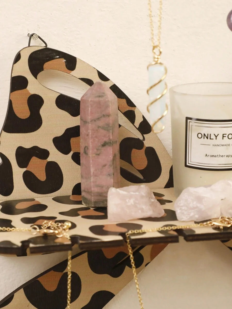 A leopard print wall mounted storage rack displaying amethyst and quartz crystals.