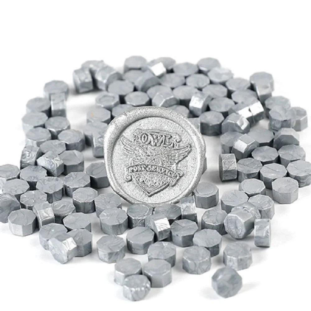 A pile of silver-gray transparent wax sealing beads for custom stamps.