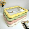 A set of wavy frame makeup mirrors in pastel shades of yellow, green, pink, and white.