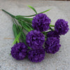 Un bouquet de fleurs artificielles d'hydrangea violettes sur une surface grise.
