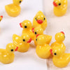 A collection of small yellow resin duck figurines arranged on a white surface.
