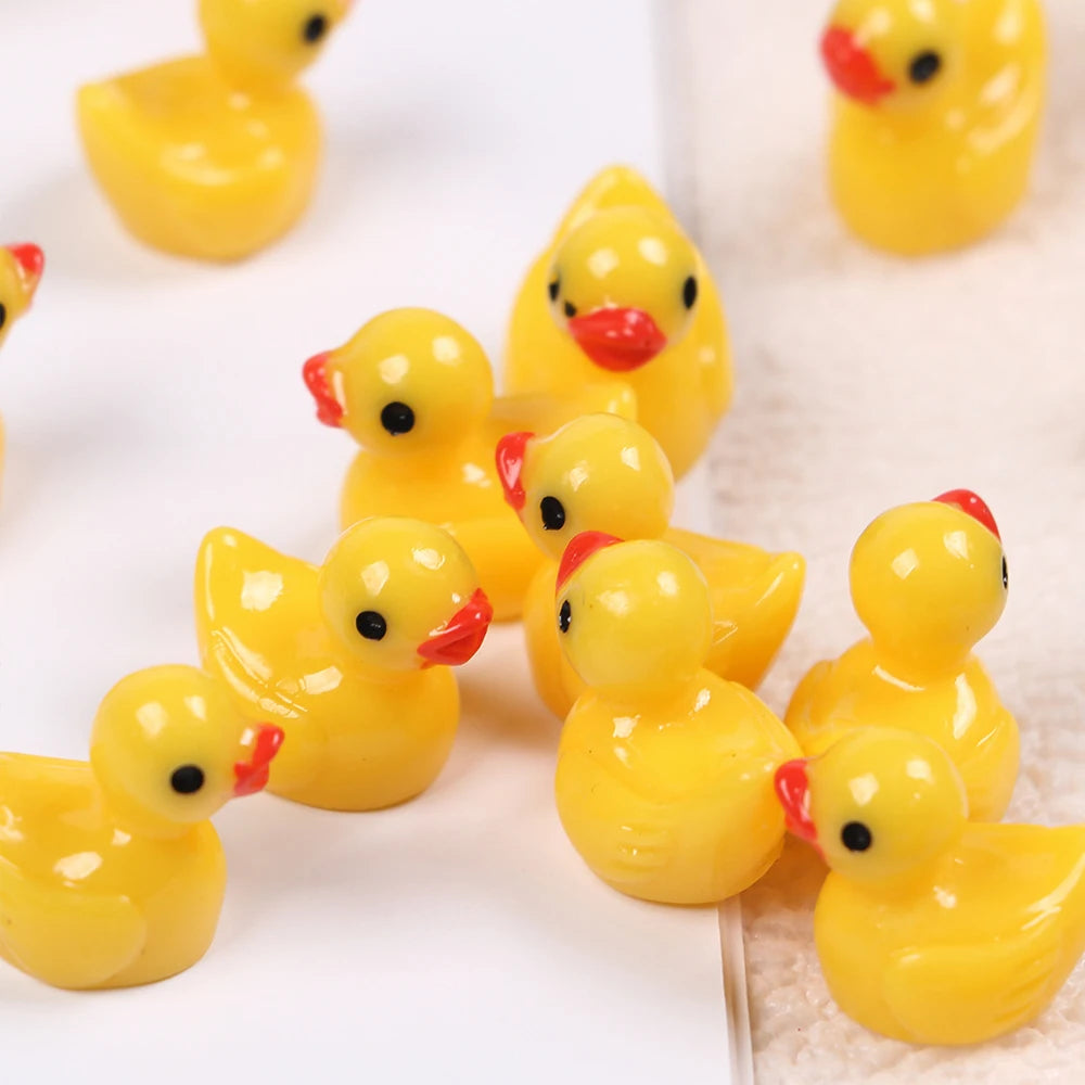 A collection of small yellow resin duck figurines arranged on a white surface.