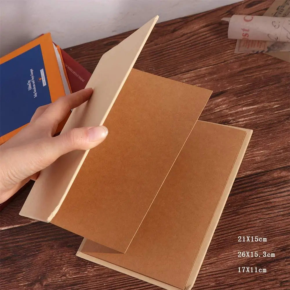 A hand is opening a brown handcrafted accordion photo album showing various sized pages.