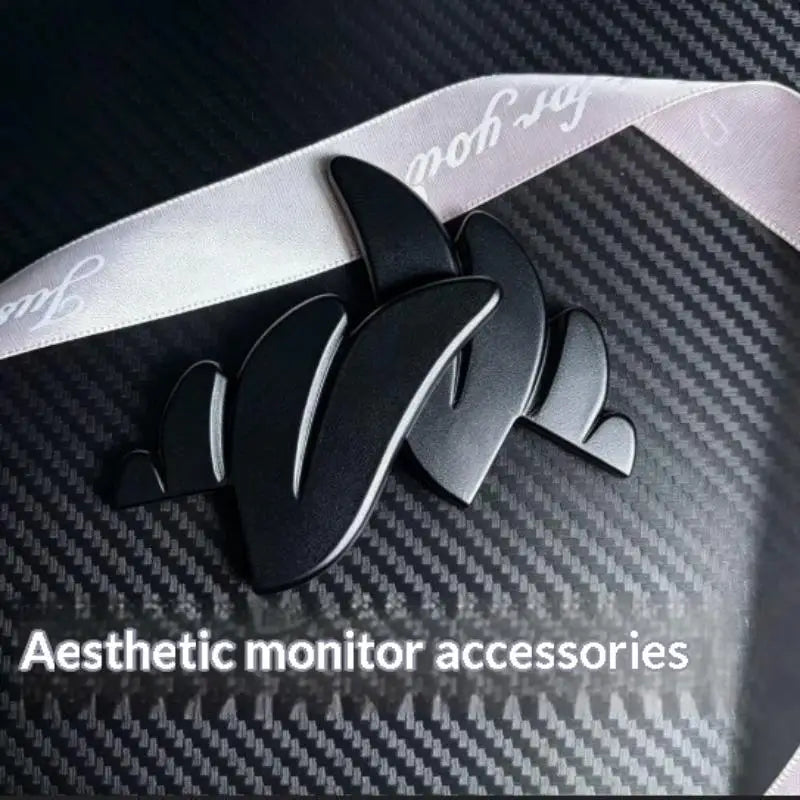 Black 3D printed LED monitor wing decorations set against a dark carbon fiber background.