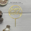 A gold acrylic birthday cake topper with the words Happy Birthday on a circular design.