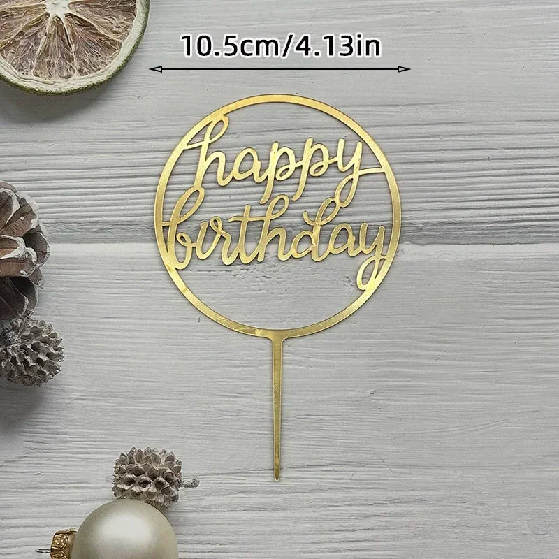A gold acrylic birthday cake topper with the words Happy Birthday on a circular design.