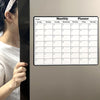 A monthly planner calendar displayed on a refrigerator door, showing days of the week and grid lines.