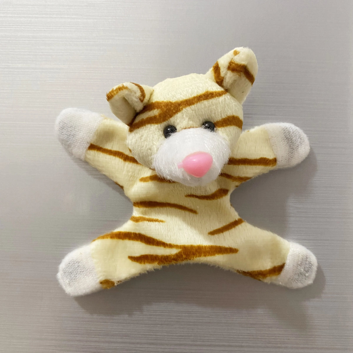 A plush toy resembling a tiger, featuring orange and white stripes and a pink nose.