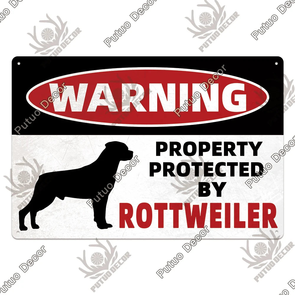 A vintage warning metal sign with red text that reads WARNING PROPERTY PROTECTED BY ROTTWEILER
