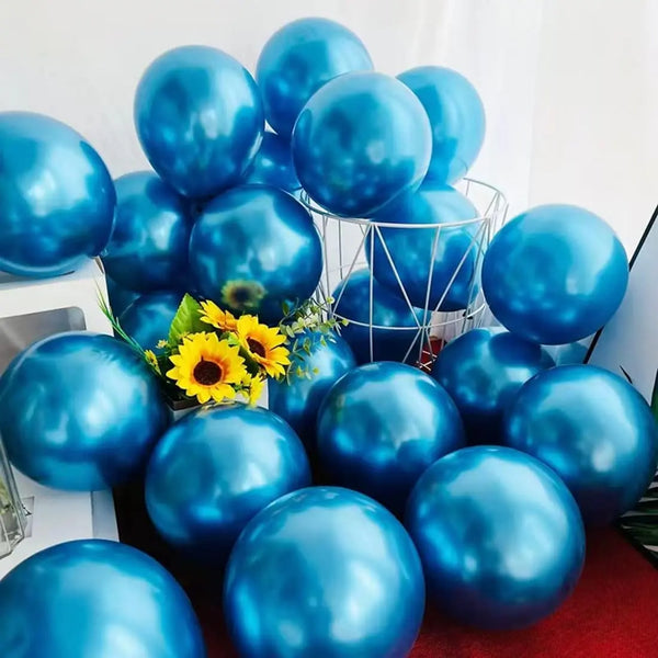 A cluster of metallic blue balloons in various sizes and shades arranged on a white surface.