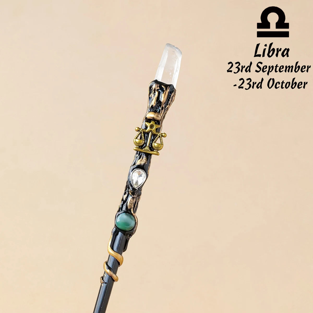 A natural clear quartz zodiac crystal wand with gold accents, displayed against a neutral background.