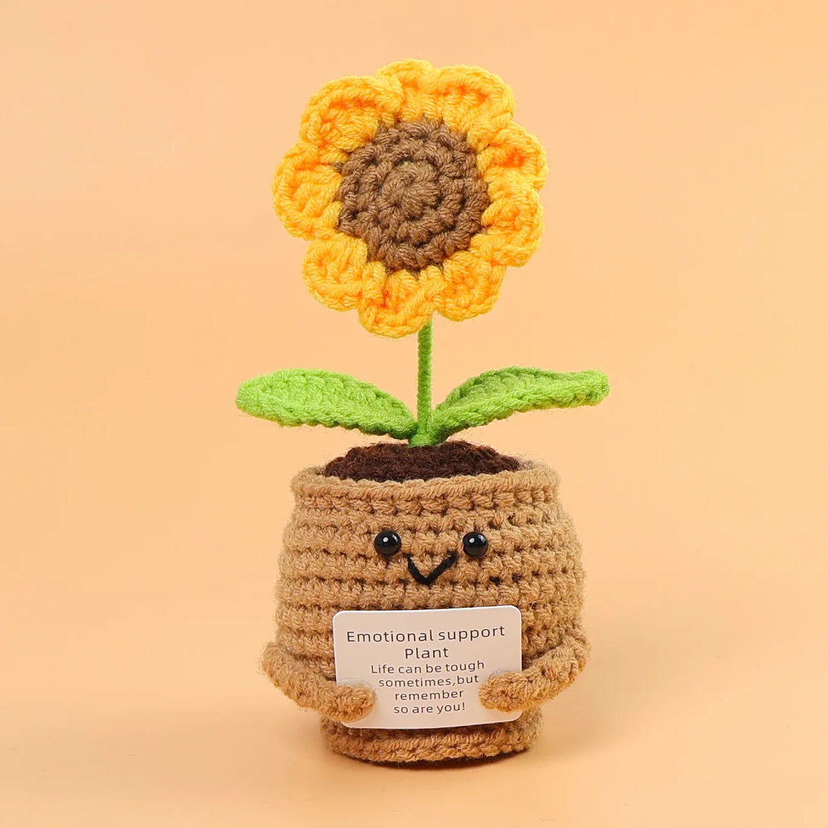 Handmade crochet sunflower desk companion with a smiling face made of yarn.