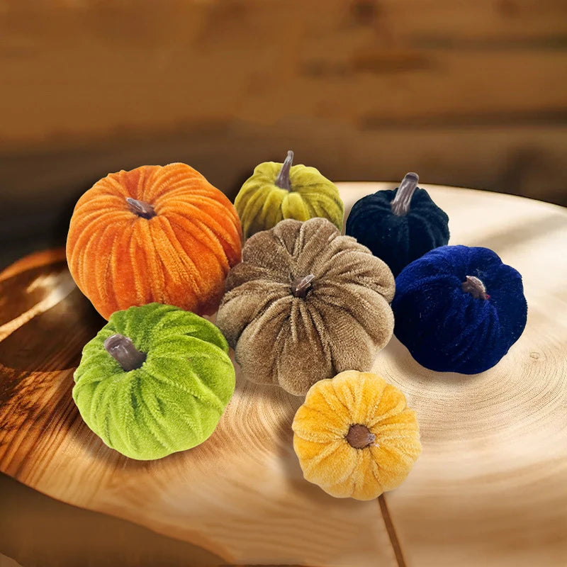 A set of five foam pumpkins in various colors including orange, yellow, green, and blue resting on a wooden surface.