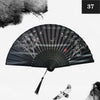A black and gray vintage silk bamboo folding hand fan with a radial pattern and a small bird detail.