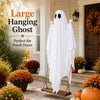 A white ghost decoration with black eyes hangs from a rope on an outdoor porch decorated with autumn foliage.