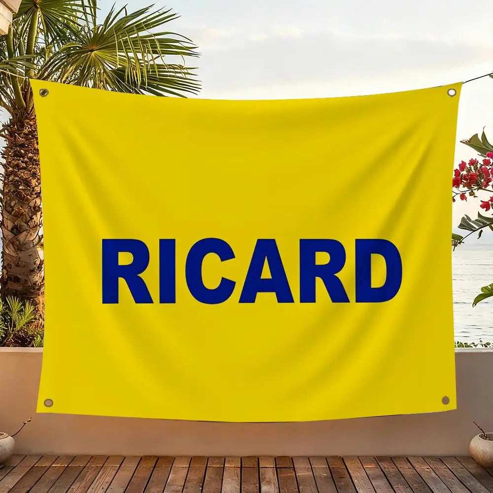 A bright yellow flag with the name RICARD printed in large blue letters, displayed outdoors.