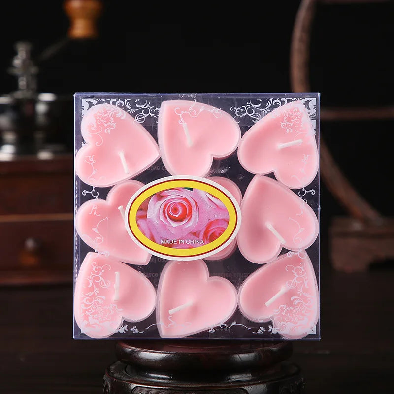 Un ensemble de bougies parfumées en forme de cœur roses emballées dans une boîte transparente.
