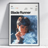 A framed poster of Blade Runner featuring a close-up portrait of a woman with smoke effects.