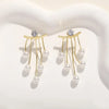 Gold-toned needle earrings featuring a diamond stud and dangling pearl tassels.